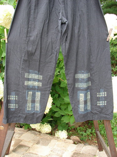 2000 Waveline Pant Grid Block Black Size 2: A pair of pants with unique grid pattern designs, made from light weight hemp. Features include a flat button front waistline, elastic back, generous hip measurement, and a slight crop length. Perfect condition.