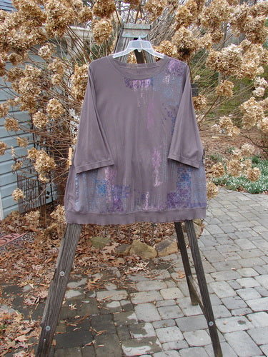 A purple shirt with a pattern on it, hanging on a clothes rack.