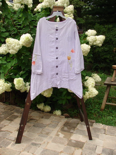 2000 Woven Hemp Sophia Cardigan Tulip Lilac Size 1: A purple shirt with a floral design on a wooden table.