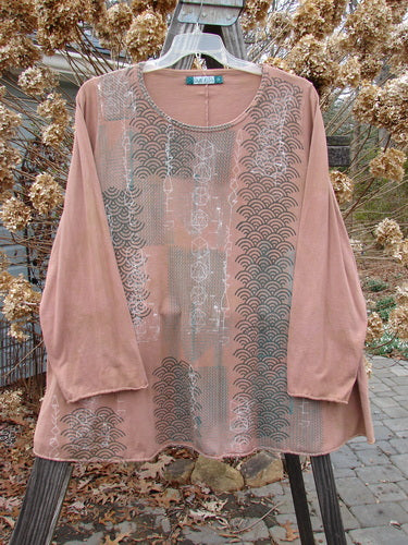 A pink shirt with a pattern on it, featuring a swinging A-line shape and long cozy sleeves. The shirt is from the Barclay Long Sleeved A Lined Tee Top Metallic Continuous Grid Mottled Carmel Size 2 collection.