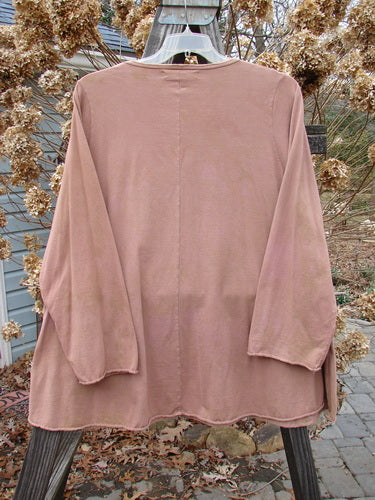 A long sleeved pink shirt on a swinger, featuring a rounded neckline, cozy sleeves, and sweet curled edgings. Made from mid-weight organic cotton with a metallic continuous grid theme paint. Size 2.