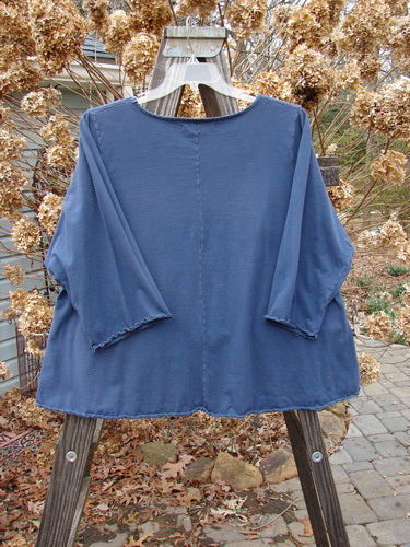 Image: A blue shirt on a wooden pole with leaves and rocks in the background.

Alt text: Barclay Three Quarter Sleeved Crop A Lined Tee Top Metallic Arrow Navy Size 2, displayed on a wooden pole with natural surroundings.