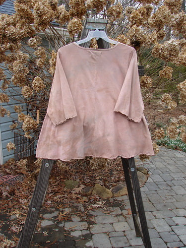 A pink shirt on a wooden stand, featuring a graduating A-line shape, rounded and rolled neckline, and sweet curly edgings. The shirt is part of the Barclay Three Quarter Sleeved Crop A Lined Tee Top Love Dove Mottled Mauve Size 2 collection from Bluefishfinder.com.