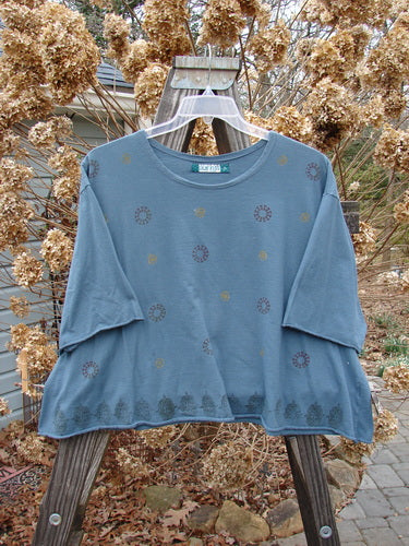Image alt text: "Barclay Crop A Lined Tee Top Continuous Pinwheel Puddle Size 2 - Short-sleeved blue shirt with a wide crop boxy shape, rounded and rolled neckline, and sweet rolled edgings."