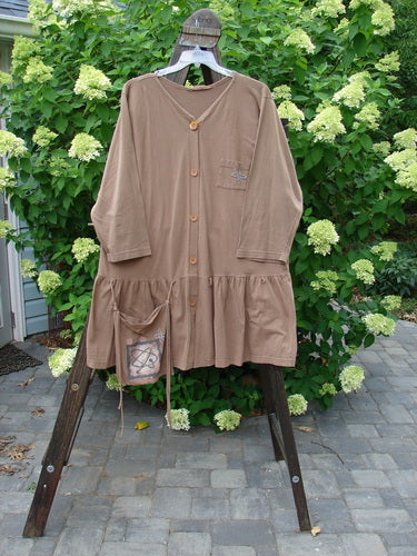 1995 Clothespin Jacket Space Travel Mudpie OSFA: A brown shirt on a rack with a long-sleeved brown shirt nearby. A person holds a wooden object. A brown cloth hangs from a ladder.
