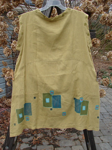 Barclay Linen Mid Layer Cap Sleeve Tunic Geometric Mustard Size 2: A yellow dress with blue squares on it, featuring a varying widening hemline, a downward curved front and rear drop empire waist seam, a mock mandarin collar, and continuous geometric theme paint.