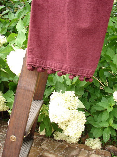 1999 Flannel PJ Pant Pom Pom Unpainted Wine Size 0: A red towel hangs from a wooden ladder in a garden with a close-up of a white flower.