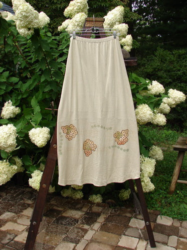 2000 Cotton Hemp Shade Skirt Bio Dove Size 1: A skirt on a rack, white flowers on a dress, and a towel.