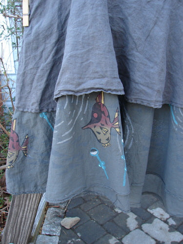Barclay Linen Two Tier Ruffle Skirt, featuring fish drawings on grey fabric. Perfect condition, with a medium weight linen upper layer and a painted batiste lower layer. Thinner elastic waistline, wider spinning double-lined fall, and a huge lower batiste ruffle. Can be worn alone or layered over a longer skirt for a triple layered look. Waist: 38-48, Hips: 58, Hem Circumference: 90, Upper Linen Length: 27, Lower Batiste Length: 34 inches.