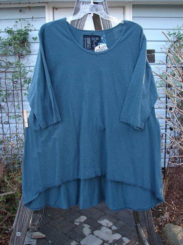 Image: A blue shirt on a clothes rack. 

Alt text: Barclay NWT High Low Top, unpainted, green mineral, size 2, on a clothes rack.