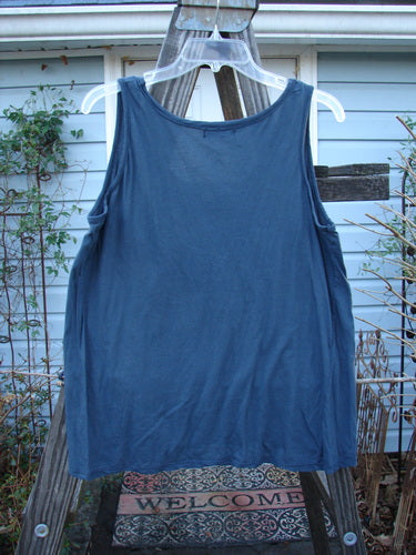 A navy Barclay Batiste Decora Tiny Tank, size 2, on a clothes rack. Slightly shorter with a front neckline tie and diagonal insert. Unpainted for easy mixing and matching.