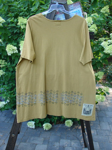 2000 Travel Tee Top with Fence Border design in Peapod. Tan shirt on a swinger with blue design. Organic cotton. Size 2.