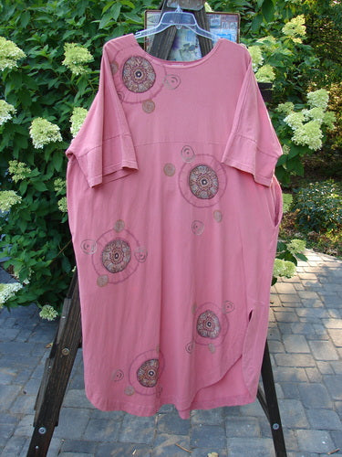 Barclay Naiad Dress Medallion Glow Size 2: A pink dress on a rack with a super tapered lower shape, generous bust measurement, rear draw cord, and shorter sectional lower sleeves. Features a super rounded and vented hemline, two deep side pockets, and the dynamic Barclay Medallion theme paint.