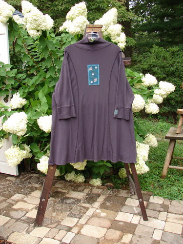 Barclay Patched Thermal Quad Drop Pocket Tunic Dress Plum Size 2: A long-sleeved shirt on a swinger with a purple shirt on top.