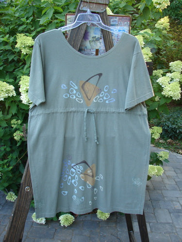 1996 Everyday Dress Step Stone Cricket Size 2: A green shirt on a wooden stand with a grey fabric hat.