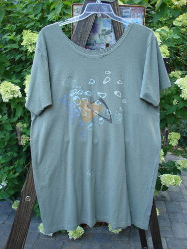 1996 Everyday Dress Step Stone Cricket Size 2: A t-shirt with a Stepping Stone design on it, worn by a person.