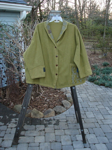 A green Barclay Patched Flannel Frolic Jacket on a swinger. Sweet roll over patched and painted neckline, contrasting lower sleeves, four unique buttons, and a super round widening hemline. Bust 66, Waist 66, Hips 68, Length 30".