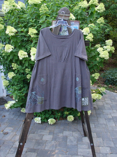 2000 Cafe Dress Directional Iron Size 2: Grey shirt on a swinger, with a clothes rack nearby.