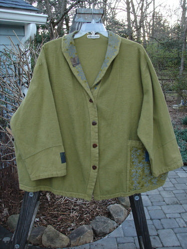 A green Barclay Patched Flannel Frolic Jacket on a swinger. Unique buttons, roll over patched neckline, and contrasting lower sleeves. Cozy and swings just great!