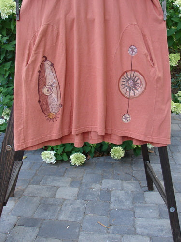 Image alt text: "1998 4 Elements Tress Weathervane Arausio Size 2 pink shirt with design on rack, close-up of circular object with spiral design"