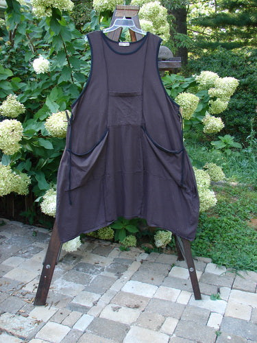 Barclay Cotton Lycra Contrast Pocket Jumper Unpainted Plum Royal Size 2: A black apron on a wooden stand, with double front flop drop pockets and a kangaroo center top pocket.