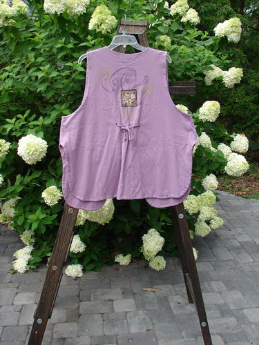 1997 Elements Dock Vest Ocean Life Jasmine Size 2: A purple vest on a wooden rack. Medium weight organic cotton. Single button closure, signature patch, high vented rounded sides, draw cord back. Bust 52, waist 54, hips 60, length 30 inches.