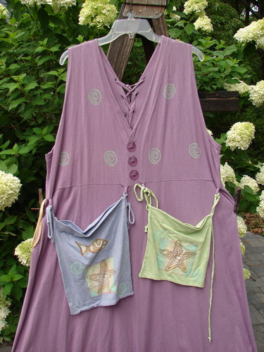 1997 Salt Water Taffy Jumper: Purple dress with pockets on a wooden pole, featuring rippie accents, front and back pockets, and ocean-themed paint. Size 2.