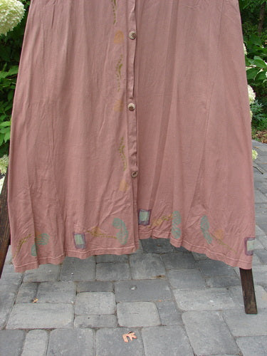1993 Sleeveless Jumper Vest Sweet Pea Dried Rose OSFA: A pink skirt with buttons, featuring deeper arm openings, a longer A-line sweep, and a deeply scooped neckline. Made from cotton jersey, this vintage piece is in perfect condition.
