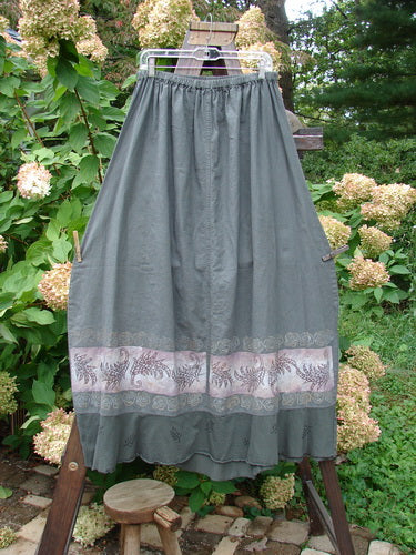 Barclay Linen Duet Skirt Green Raven Size 2: A skirt on a stand with a seriously widening bell shape, sectional panels, and a varying hemline.
