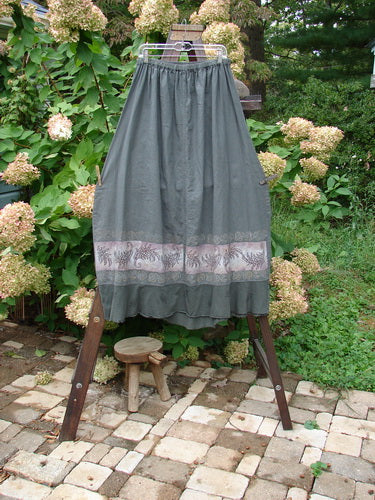 Barclay Linen Duet Skirt Green Raven Size 2: A skirt with a widening bell shape, V-shaped insert, and varying hemline. Made from a unique cotton linen combination.