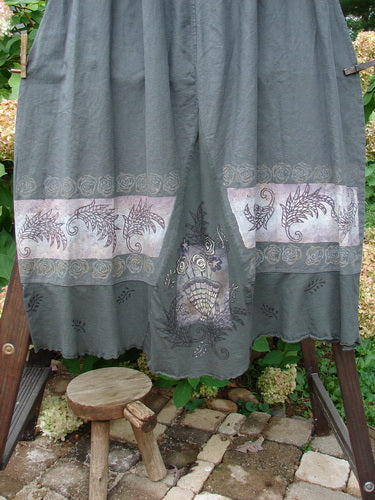 Barclay Linen Duet Skirt Green Raven Size 2: A grey curtain on a clothesline with a wooden stool and a grey skirt with a design on it. A close-up of a keyboard and a metal railing. A close-up of a carpet.