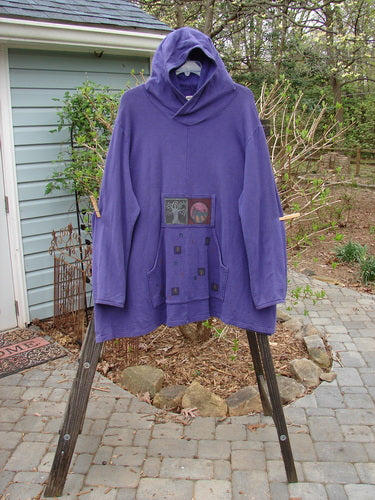 A purple hooded sweatshirt with a patch on it, from the Barclay Cotton Hemp Fleece Friendly Autumn Pullover Tree of Life Royal Orchid collection. Features include a cozy overlap front hoodie, a front drop kangaroo pocket with a painted tab, and an A-line vented lower. Bust 62, waist 62, hips 64, sweep 70, and length 35 inches.