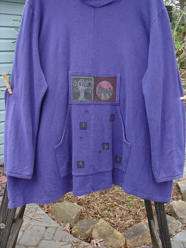 A purple jacket with a patch on it, from the Barclay Cotton Hemp Fleece Friendly Autumn Pullover Tree of Life Royal Orchid OSFA collection. Cozy overlap front hoodie, drop kangaroo pocket, A-line vented lower, and painted Tree of Life design.