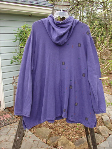 A purple jacket with a hood on a clothes rack, part of the Barclay Cotton Hemp Fleece Friendly Autumn Pullover Tree of Life Royal Orchid collection. Features include a cozy overlap front hoodie, a front drop kangaroo pocket, and an A-line vented lower. Bust: 62, Waist: 62, Hips: 64, Sweep: 70, Length: 35 inches. Made from heavy-weight organic cotton jersey fleece.