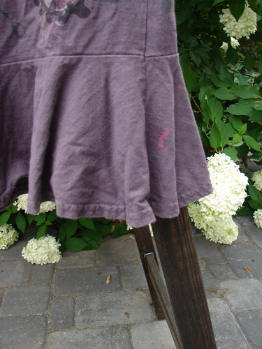 1996 Spring Laughter Skirt in Violet Field, Size 2: A ruffled purple skirt on a wooden stand, featuring a vine blossom theme paint and a fun flounce with an 8-inch lower band.