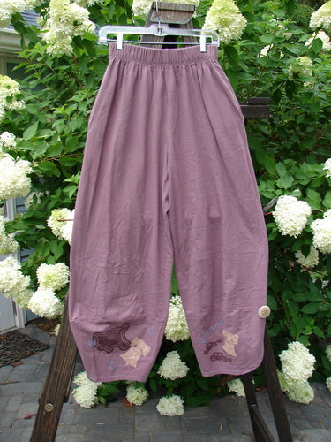 1996 Boulevard Pant Old Car Travel Laurel Size 1: Purple pants on a rack, featuring elastic waistline, side seam pockets, and painted cuffs with cloth covered buttons. Made from organic cotton.