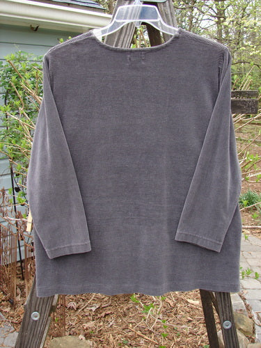 1999 Patched Stretch Cord Pullover Top Leaf Grey Plum Size 0: A grey shirt with a leaf patch on the front. Made of stretch cotton corduroy, it has a rounded neckline, drop shoulders, and a slight A-line shape. Very comfortable and plush.