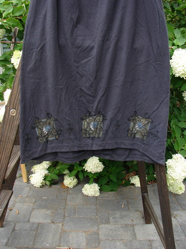 1999 Winter Skirt Celtic Five Raven Size 2: A black towel on a wooden ladder, with a close-up of a rug.