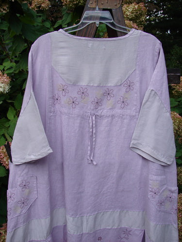 Barclay Linen Contrast Drop Pocket Dress Tiny Flower Heathered Lilac Size 2: A lovely dress with a widening shape, detailed fabric alternation, and a sweet bottom flutter flounce. Features a squared off neckline and shallow side drop pockets.