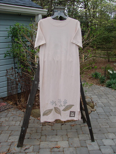 A white shirt on a rack, part of the 1999 Straight Dress Window Chair Teadye Size 0 collection. Features include rounded side entry front pockets, a paneled neckline, widening hips, and a vented hemline. Made from organic cotton.