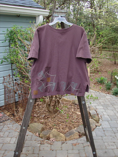 1998 Camp Shirt Triangular Star Madeira Size 1: A purple shirt with a design on it, featuring a straighter boxier shape, vented hemline, and oversized front breast pocket.