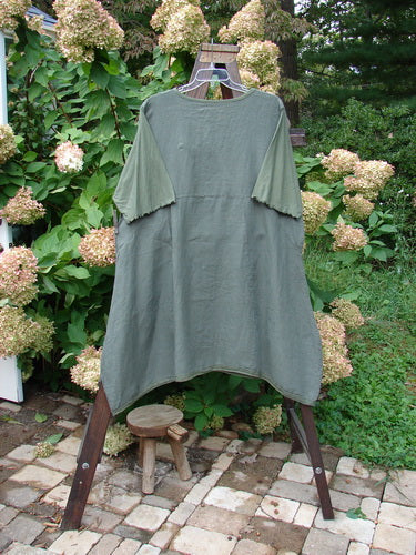 Barclay Linen Lace Blooming Tunic Dress Unpainted Army Size 2: A green shirt on a rack with a small wooden stool underneath.