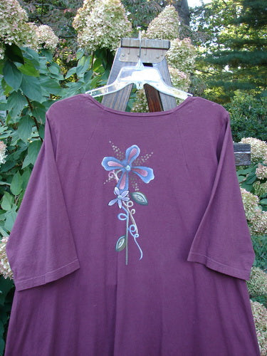 Barclay Short Penny Dress Garden Show Red Plum Size 2: A purple shirt with a flower painted on it, featuring a sweet rounded neckline, longer widening shape, and painted pockets.