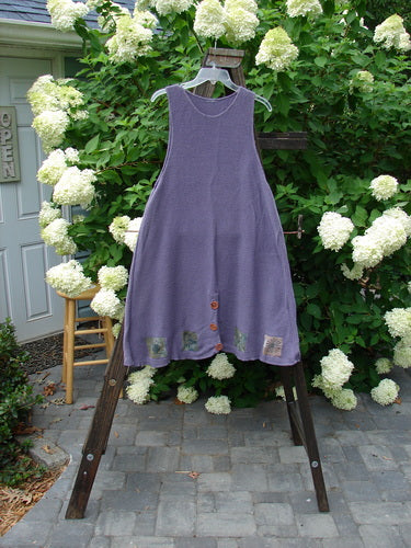 1994 Vent Vest Sweater Jumper Sea Life Periwinkle OSFA: A purple dress on a wooden rack, with floral design and outdoor elements.