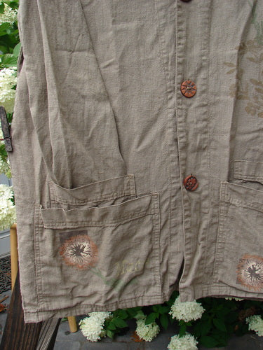 1998 Botanicals Herbary Jacket, a close-up of a jacket with ceramic buttons, painted pockets, and a botanical theme. Made from heavy weight linen.