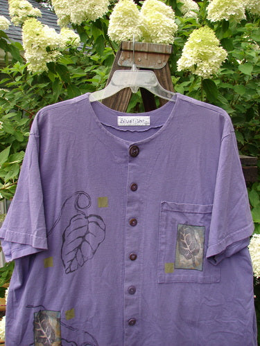 1998 Camp Shirt Falling Leaf Modena Size 2: A purple shirt with a leaf design, featuring a vented hemline, oversized front pocket, and Blue Fish patch.
