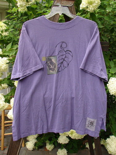 1998 Camp Shirt Falling Leaf Modena Size 2: A purple t-shirt with a leaf design on it. Straighter boxier shape, vented hemline, oversized front breast pocket, and shirt tail like hem.