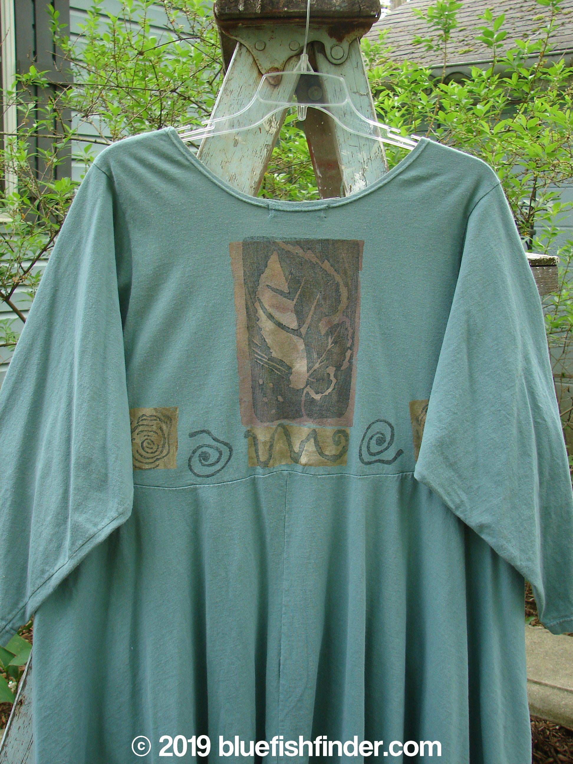 1994 Juniper Dress Swirl Leaf Sea Journey Size 2: A vintage green dress with a leaf and swirl design. Features a rounded collar, recycled paper button closures, and a sweeping swing lower.