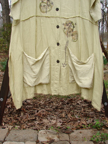 A white Barclay Silk Linen Collar Coat with pockets on a clothes rack, featuring a deep V-shaped neckline, prominent pointed collar, and contrasting fabrics of silk and linen.