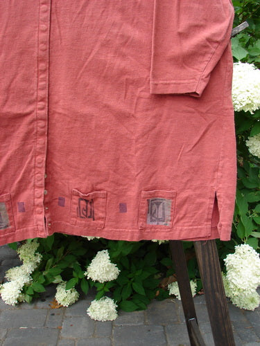 1993 Sticks and Stones Jacket: A close-up of a red shirt with a deep V-shaped neckline and tiny front snaps. Features include vented sides and painted pockets.